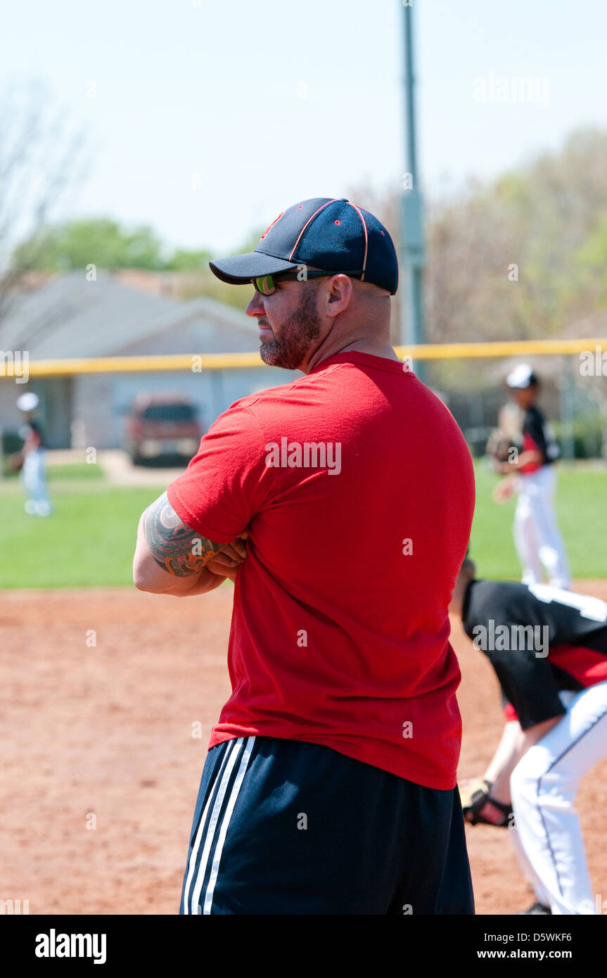 Baseball coach at first base line looking at batter Stock Photo Alamy