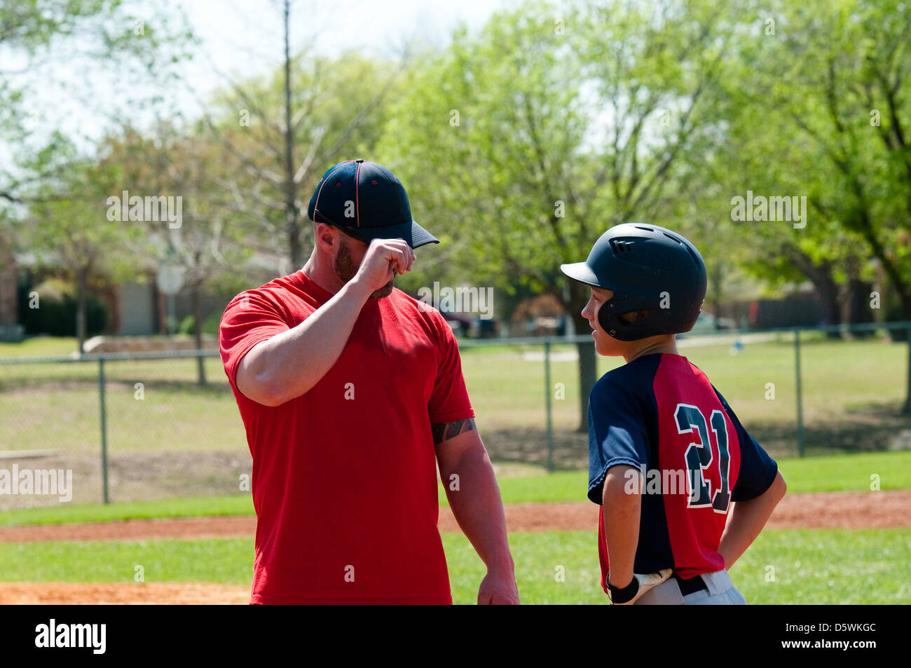 Baseball coach giving signals to teen player Stock Photo Alamy
