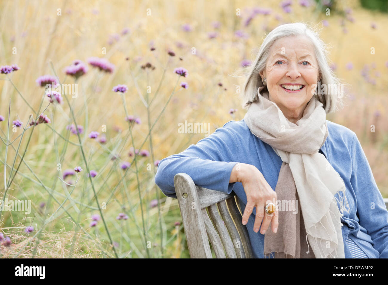 Older woman sitting on park bench Stock Photo