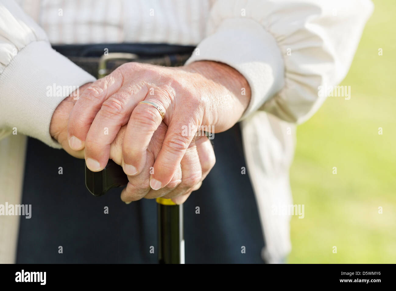 Close up of older man's hands on cane Stock Photo