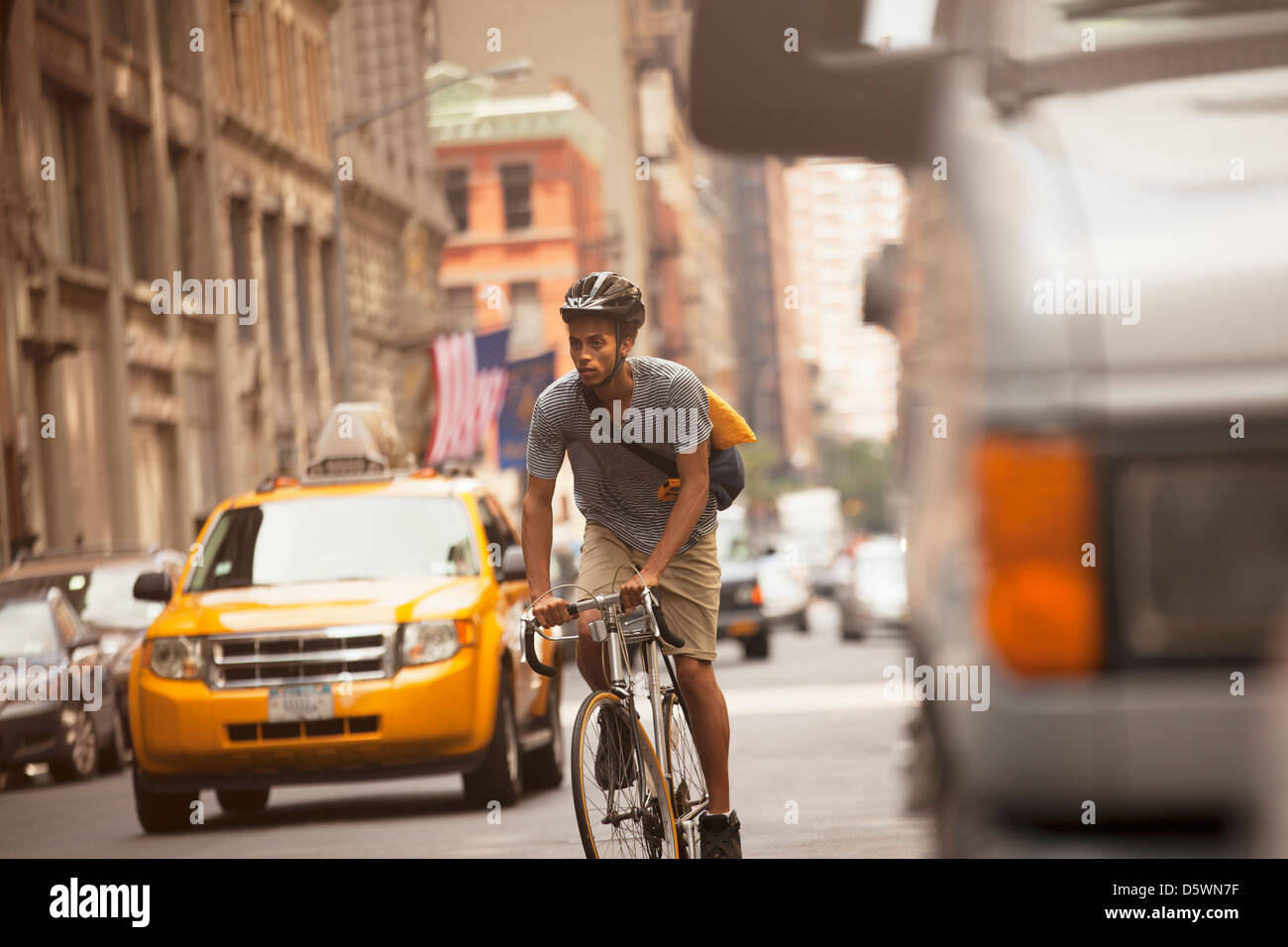 Man riding bicycle on city street Stock Photo