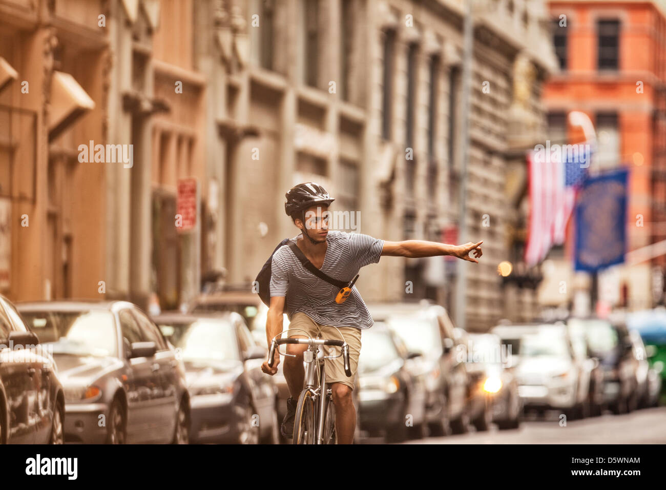 Man riding bicycle on city street Stock Photo