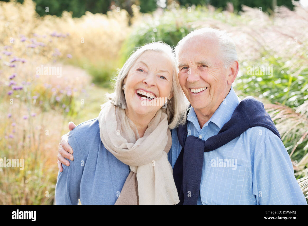 Older couple hugging outdoors Stock Photo