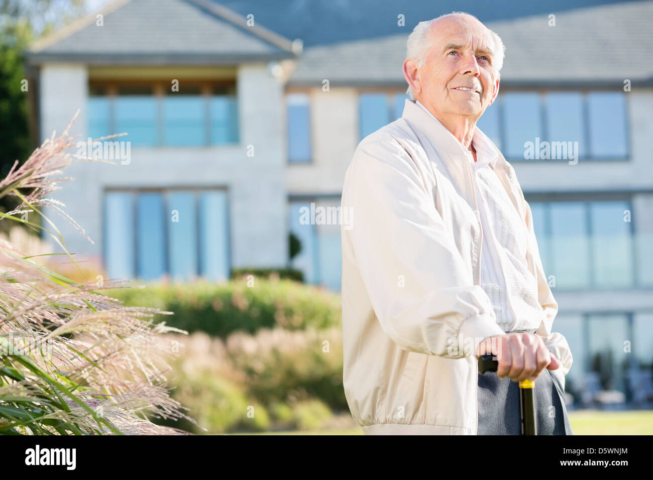 Older man walking with cane outdoors Stock Photo