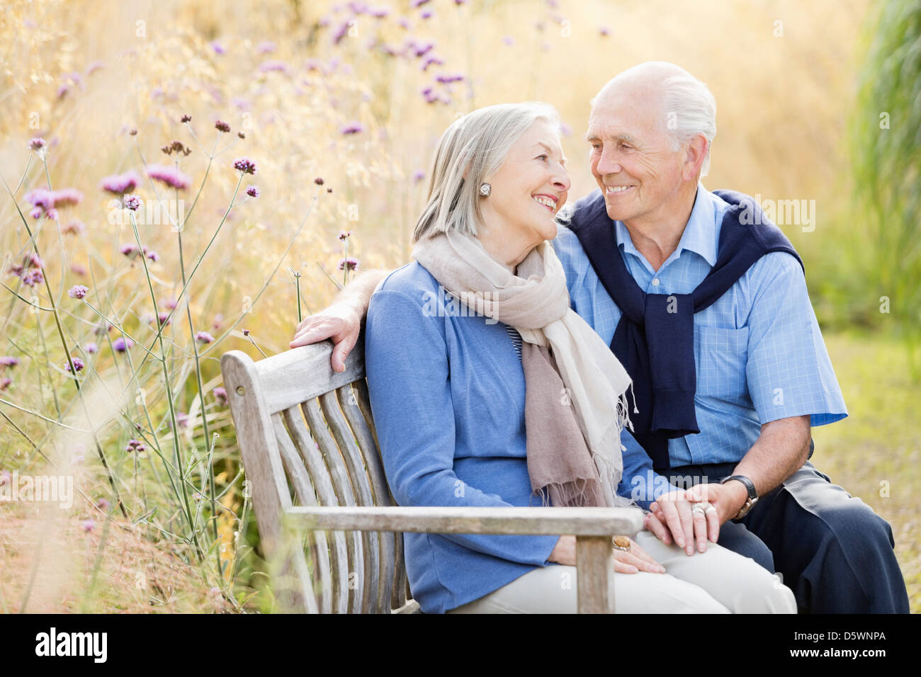 Older couple relaxing on park bench Stock Photo