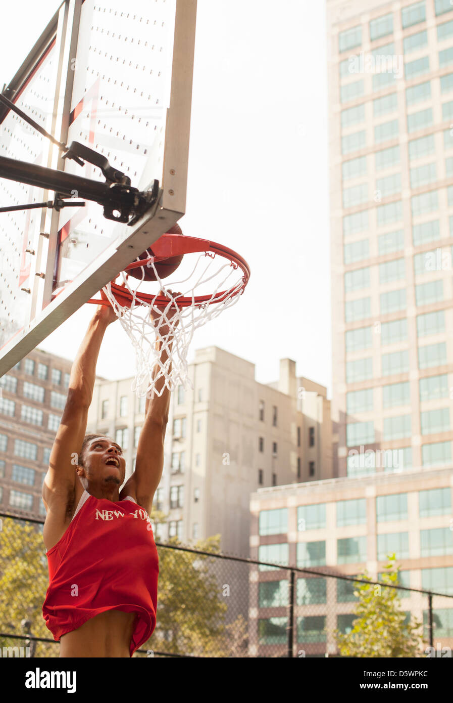 Man dunking basketball on court Stock Photo Alamy