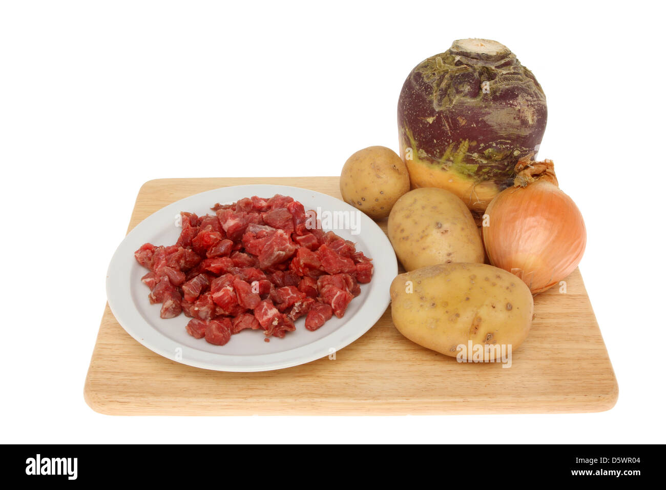 Basic ingredients for the filling of a Cornish pasty, beef,swede,potato and onion on a wooden board isolated against white Stock Photo