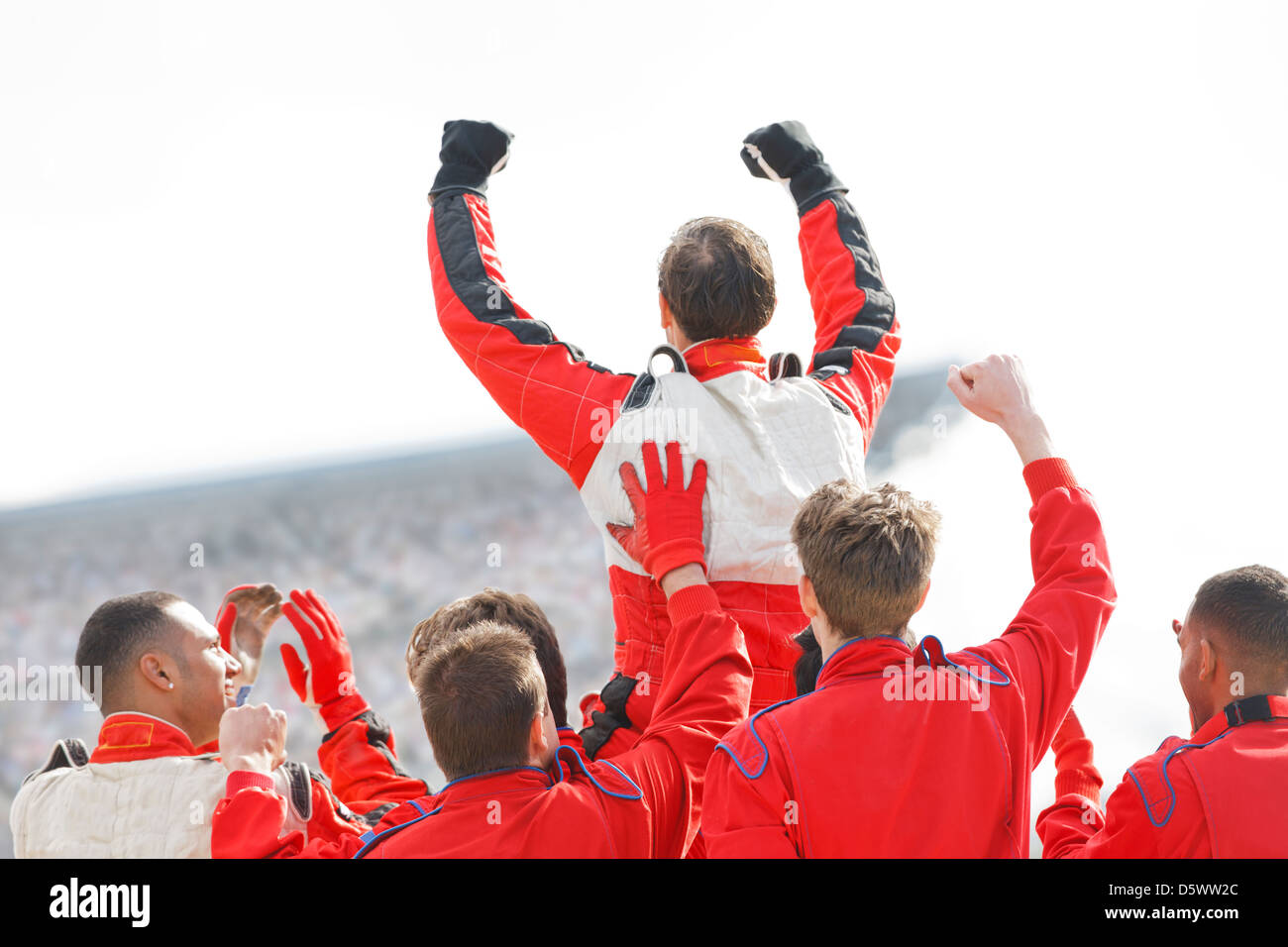 Racer and team cheering on track Stock Photo