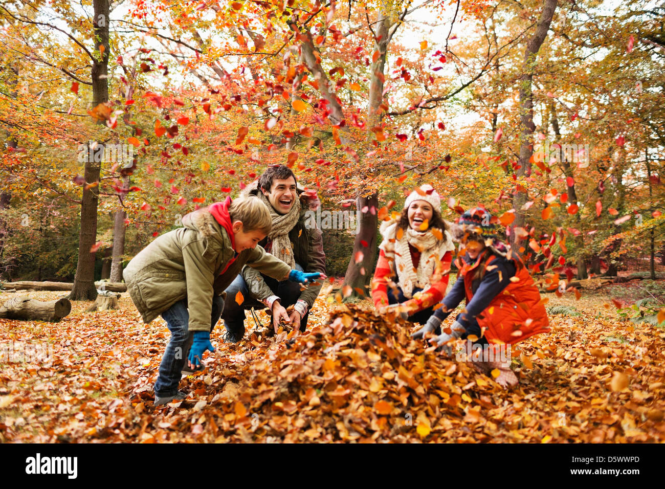 Family playing in autumn leaves Stock Photo