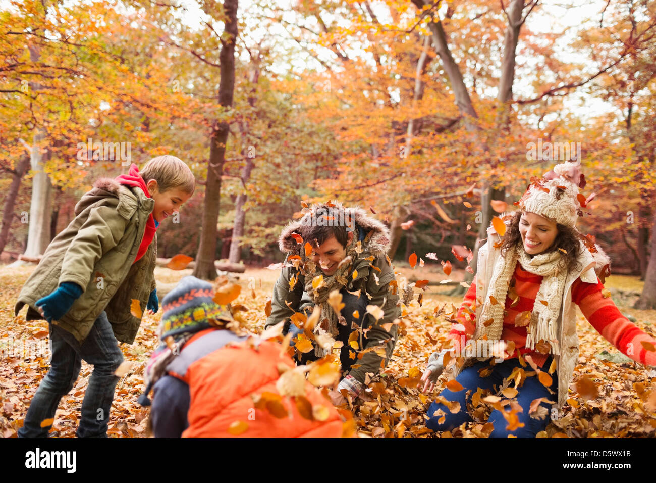 Family playing in autumn leaves in park Stock Photo
