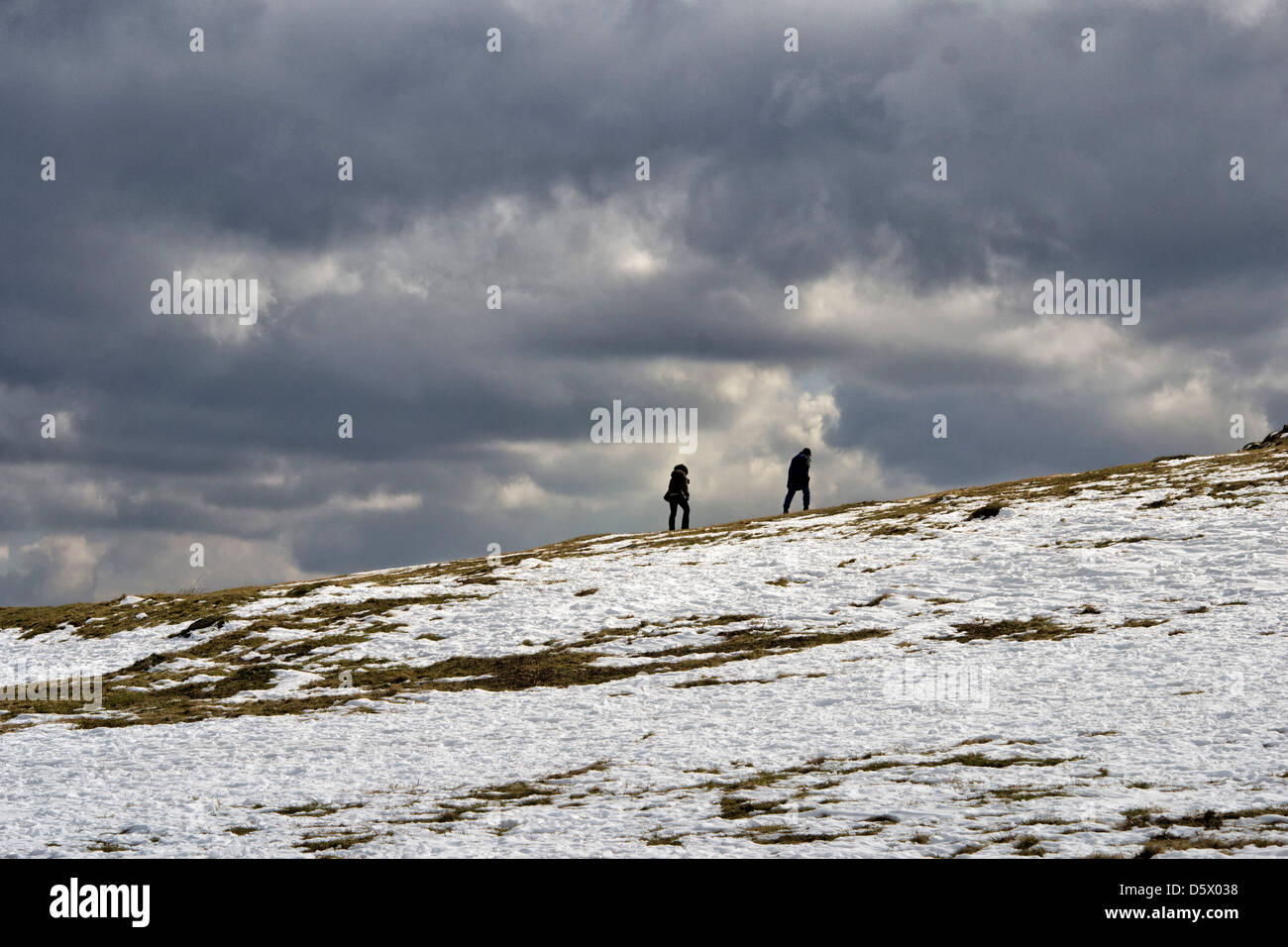 Image of two people walking in the snow at Bradgate Country Park, Leicestershire, England, UK Stock Photo