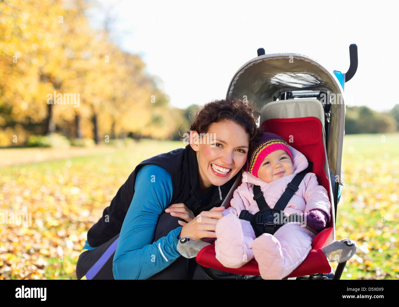 Woman smiling with baby in stroller Stock Photo
