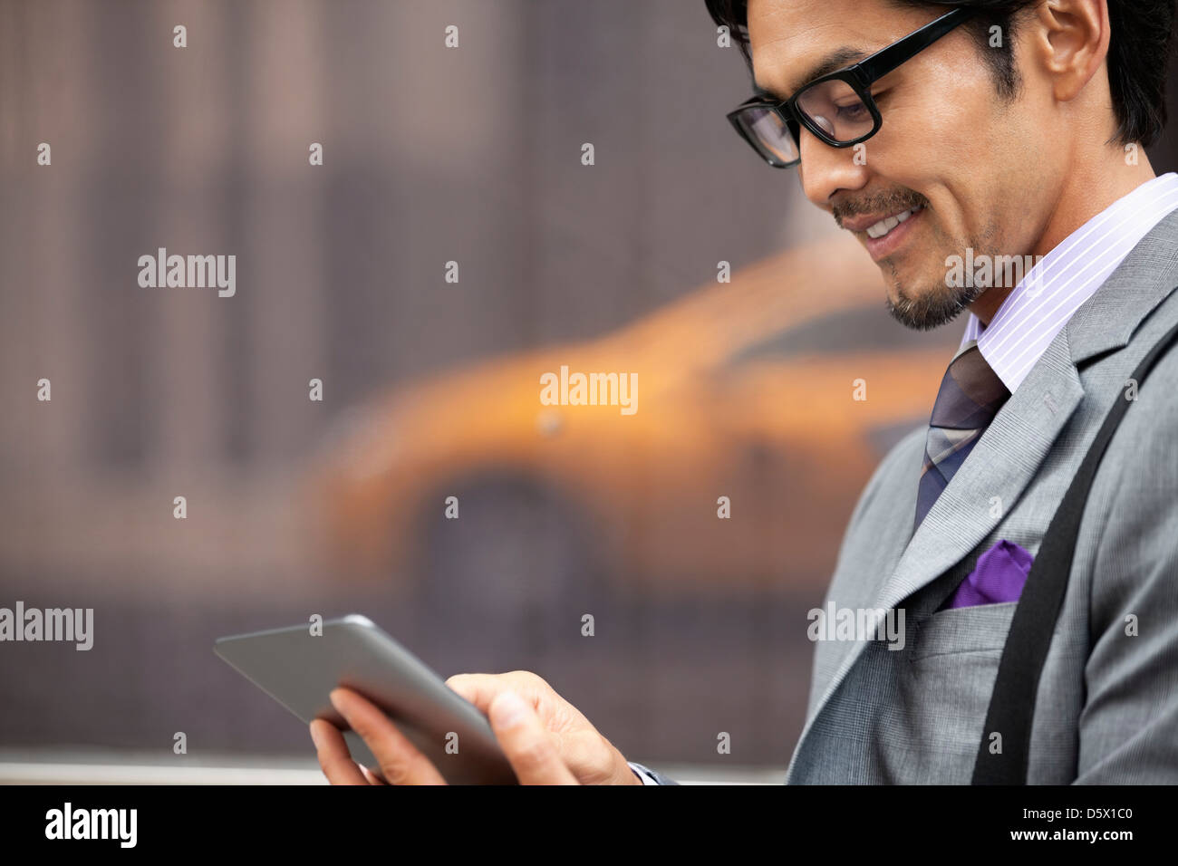 Businessman using tablet computer on city street Stock Photo - Alamy