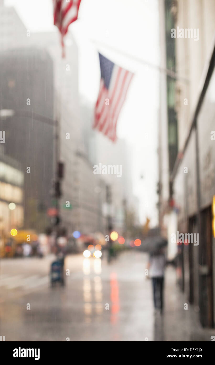 Blurred view of American flags on city street Stock Photo