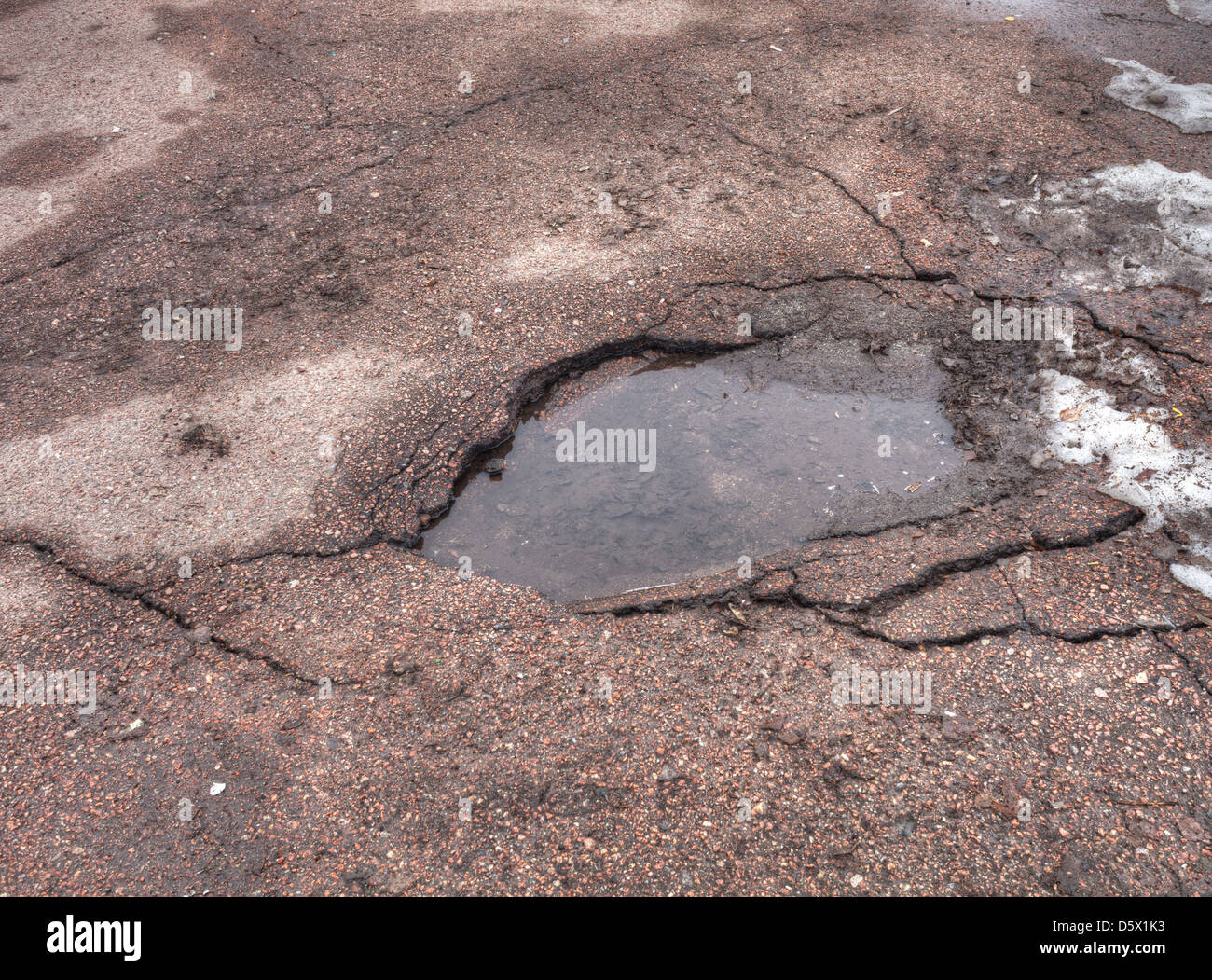 Pothole in road after spring thaw Stock Photo