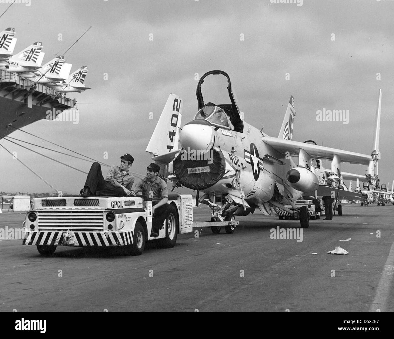 Sailors tow a LTV A-7E 'Corsair II' of Attack Squadron (VA) 195 to a position for loading onto the USS KITTY HAWK (CV-63) at NAS North Island, California. Stock Photo