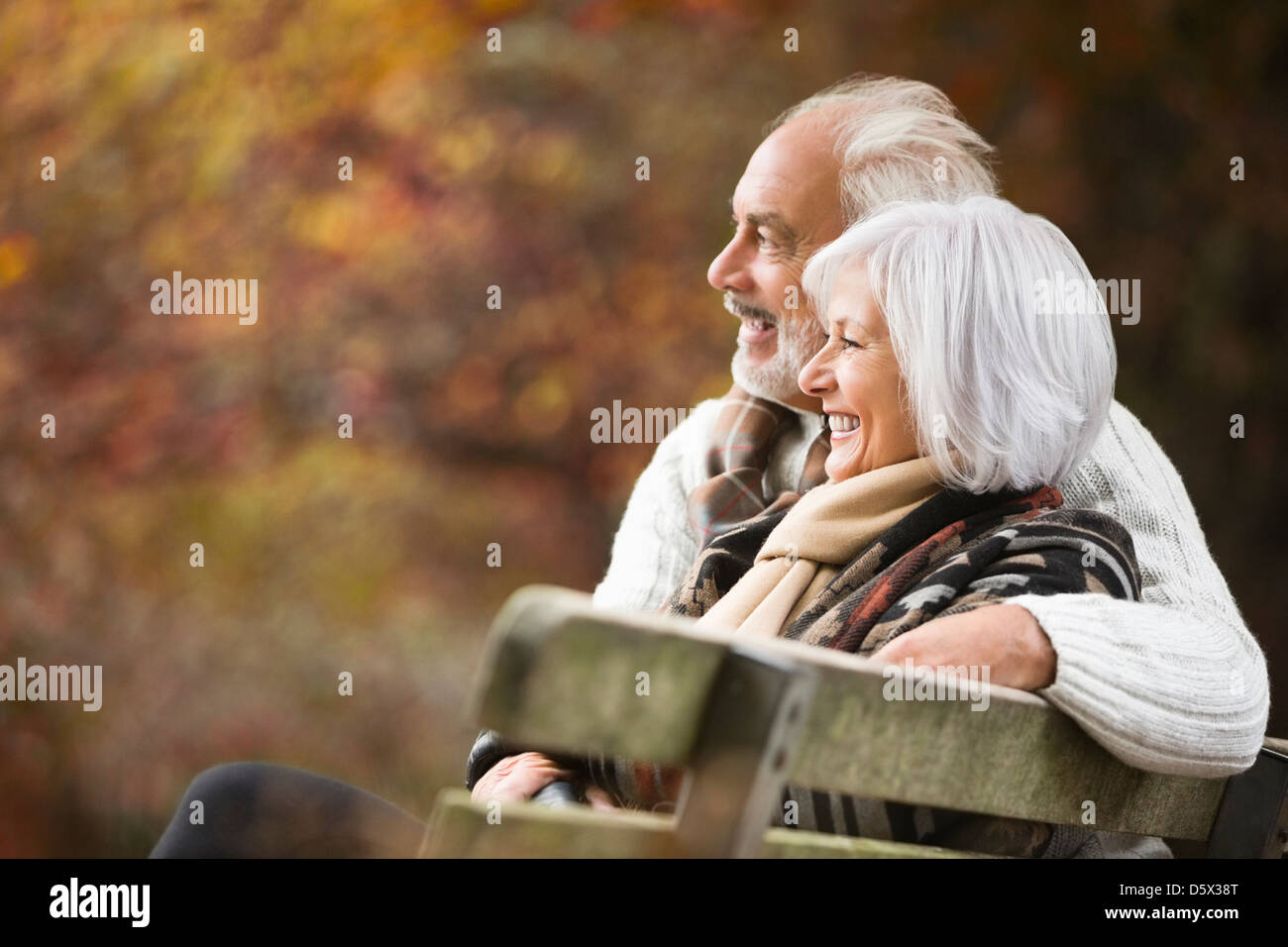 Older couple sitting on park bench Stock Photo - Alamy