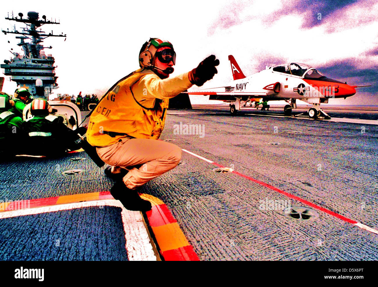 US Navy (USN) Lieutenant Commander (LCDR) Sherman Scott, a Aircraft Handling Officer, gives the launch signal to a USN T-45A Goshawk aircraft from Training Squadron Seven (VT-7), as the aircraft prepares to launch, during final qualifications aboard the USN Aircraft Carrier USS GEORGE WASHINGTON (CVN-73). Stock Photo