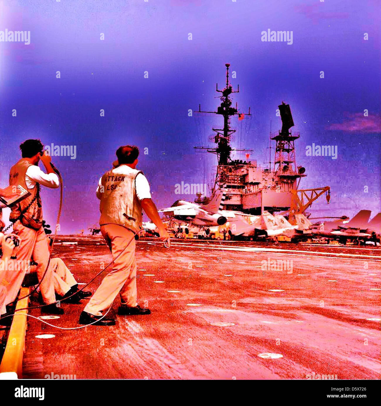 Landing Signal Officers (LSO) observe a LTV A-7 "Corsair II" on board the USS MIDWAY (CV-41). Stock Photo