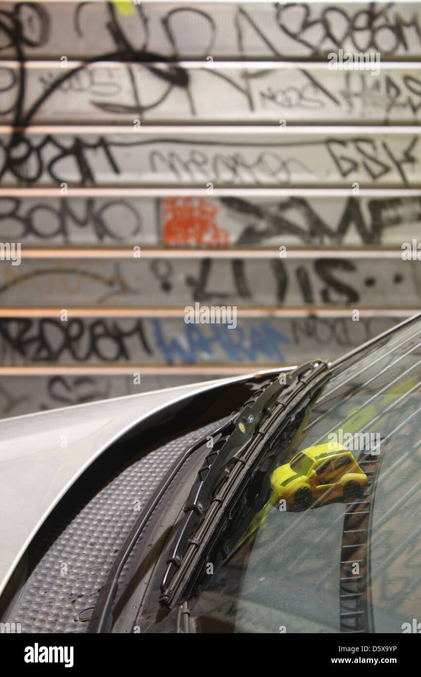 toy car in window with graffiti on shop shutters in rome italy Stock Photo Alamy