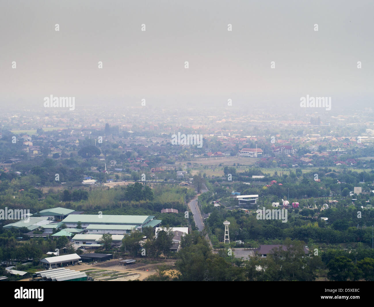 April 6, 2013 - Chiang Mai, Chiang Mai, Thailand - The view from the scenic overlook at Wat Phra That Doi Kham (Temple of the Golden Mountain) in Chiang Mai is obscured by smoke from illegal burning going on around the city. The ''burning season,'' which roughly goes from late February to late April, is when farmers in northern Thailand burn the dead grass and last year's stubble out of their fields. The burning creates clouds of smoke that causes breathing problems, reduces visibility and contributes to global warming. The Thai government has banned the burning and is making an effort to cont Stock Photo