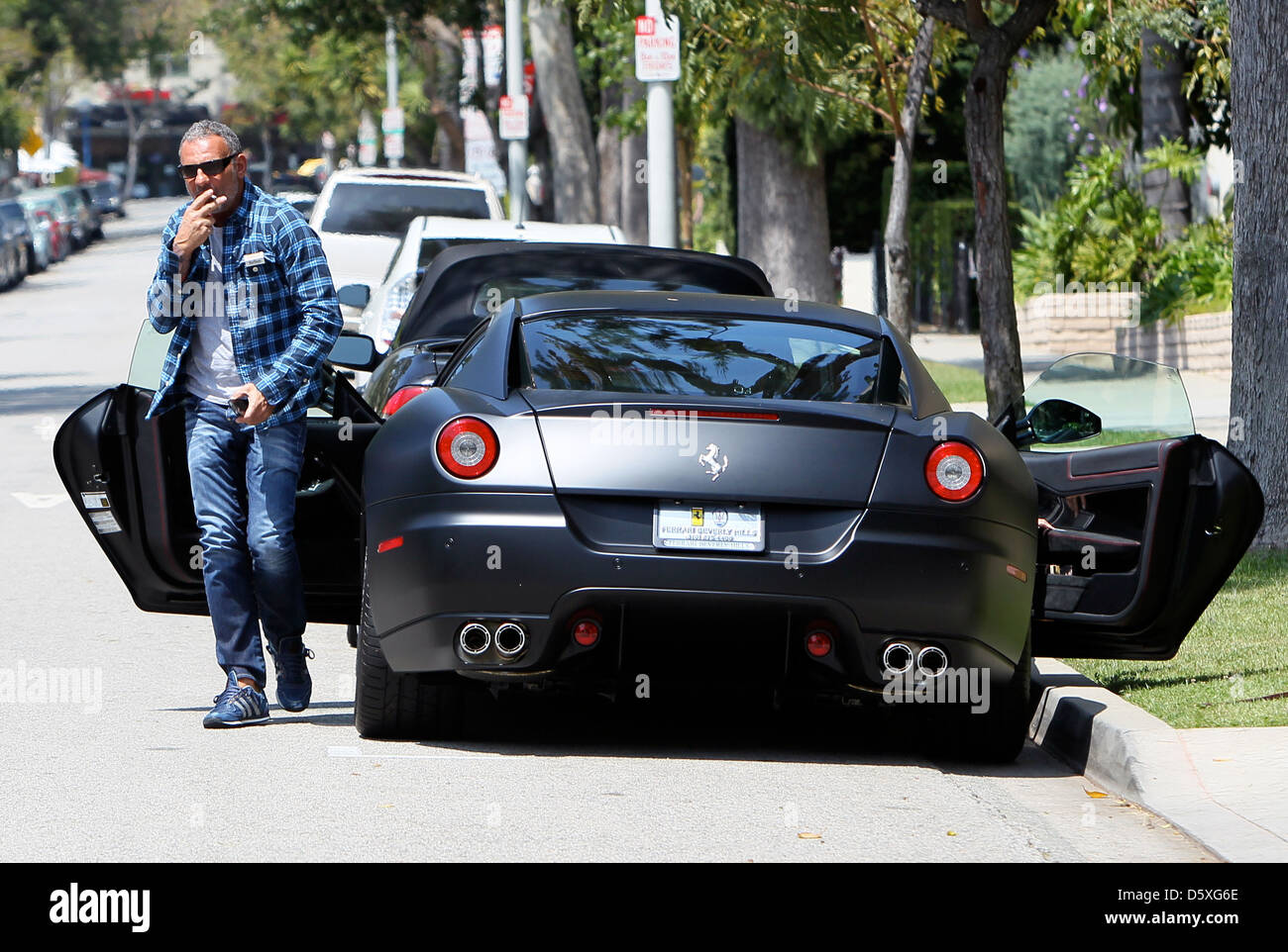 christian audigier and his girlfriend drive his matte black ferrari