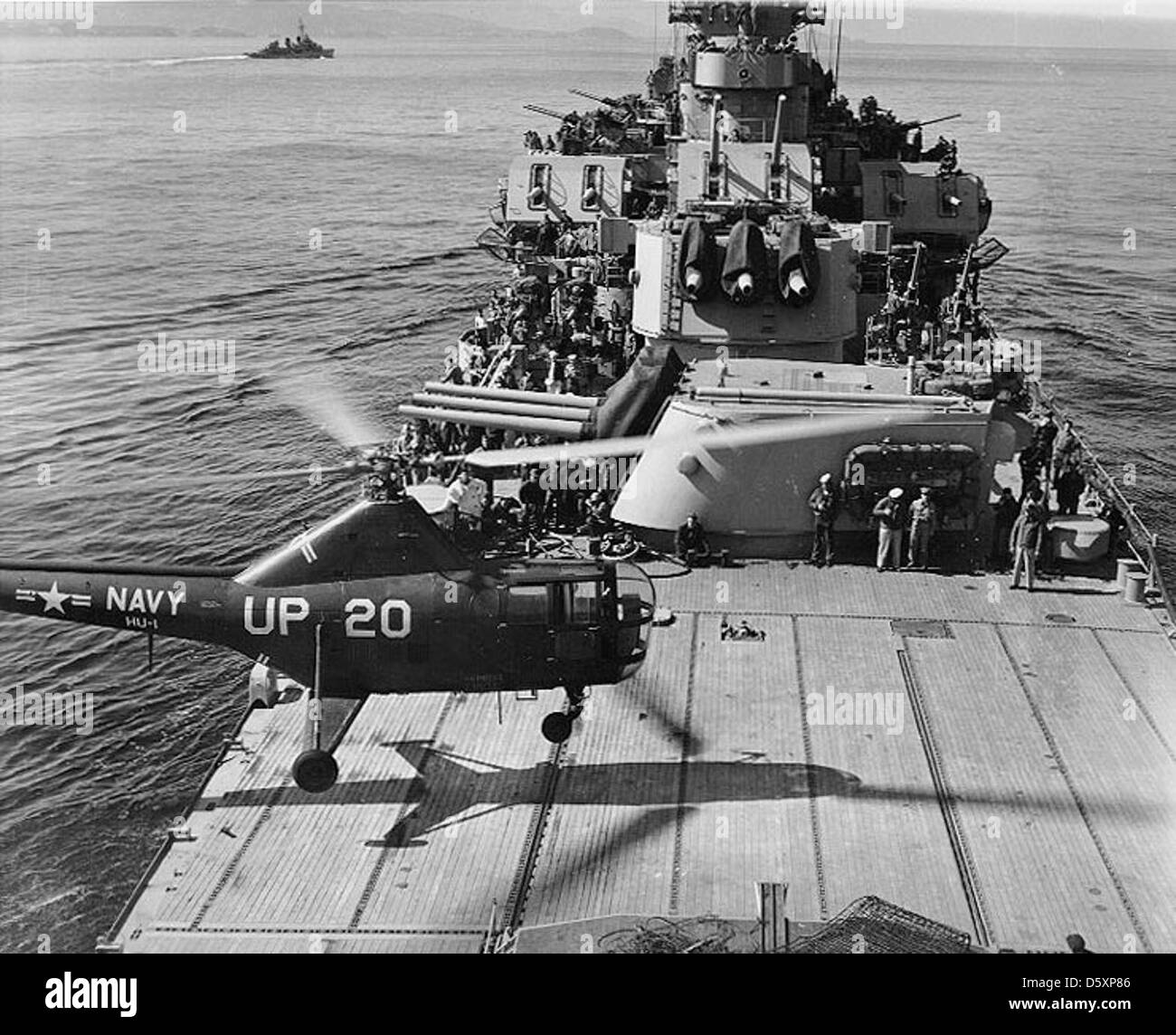 USS Manchester (CL-83) Sikorsky HO3S helicopter, of squadron HU-1, lands on the cruiser's after deck after a gunfire spotting mission off the Korean coast, March 1953. Stock Photo