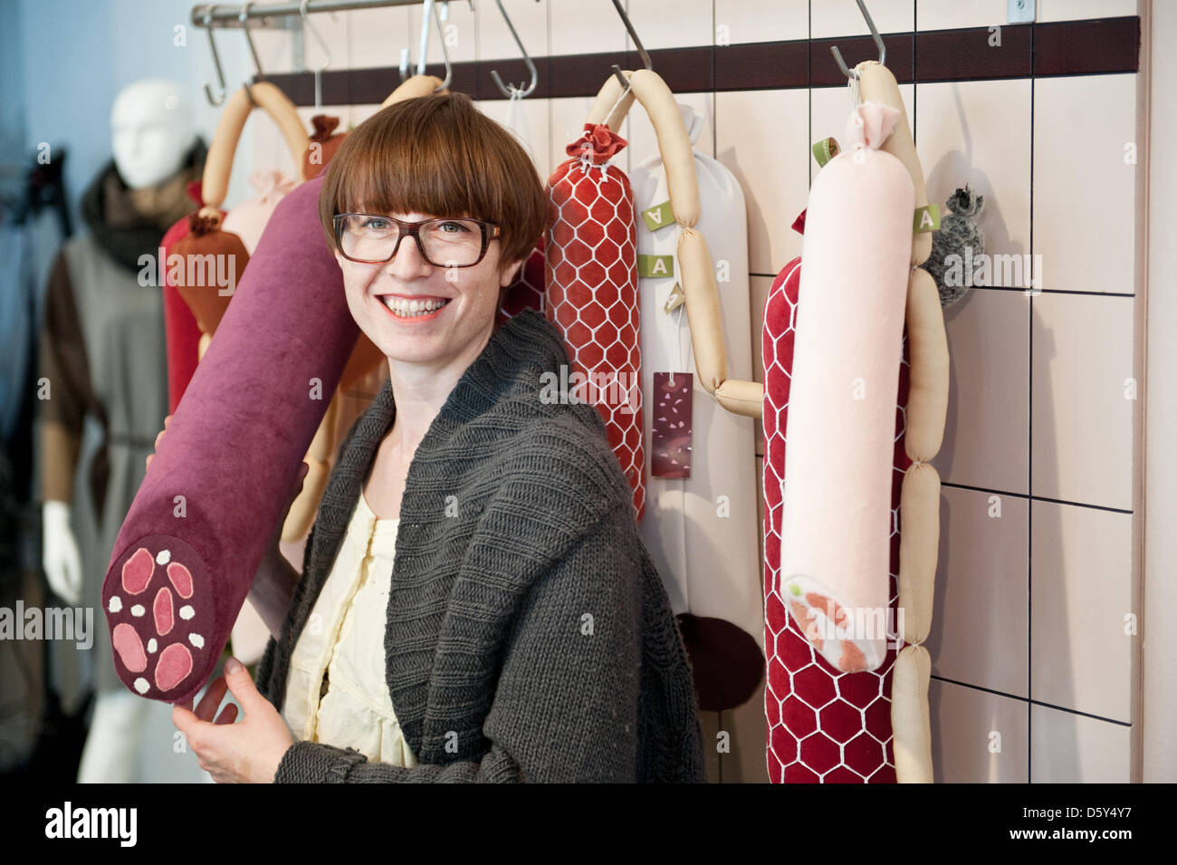 Artist Silvia Wald poses with blood sausage made of cloth at her fashion studio 'Aufschnitt' (Cut) in Berlin, Germany, 10 October 2012. Under the motto 'Fleshy Fluffy ' the Berlin artist imitates meat and saussages of all kinds. Photo: Robert Schlesinger Stock Photo