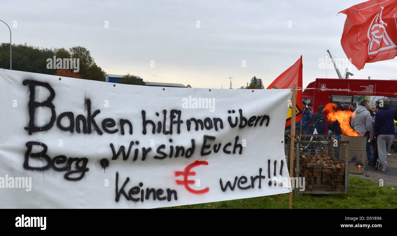 Employees of the Siag Nordseewerke shipyard stand next to a banner which reads 'Banks are supported. We are not worth a single euro to you!' during a solemn vigil in front of the gate of the shipyard in Emden, Germany, 17 October 2012. The struggling offshore supplier with around 700 emplyees has filed for insolvency. The district court Aurich confirmed that such a request had been Stock Photo