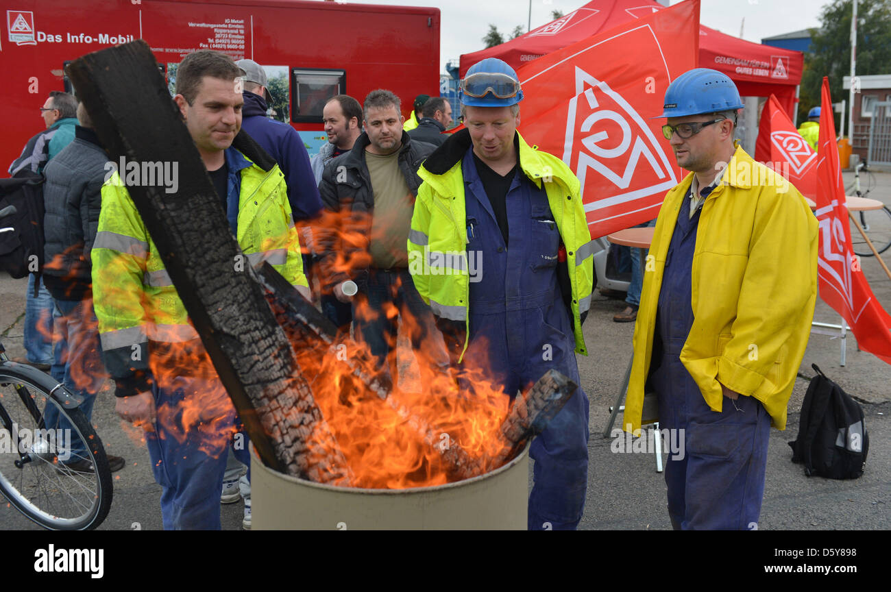 Employees of the Siag Nordseewerke shipyard stand around a fire during a solemn vigil in front of the gate of the shipyard in Emden, Germany, 17 October 2012. The struggling offshore supplier with around 700 emplyees has filed for insolvency. The district court Aurich confirmed that such a request had been filed on 17 October 2012. Photo: CARMEN JASPERSEN Stock Photo