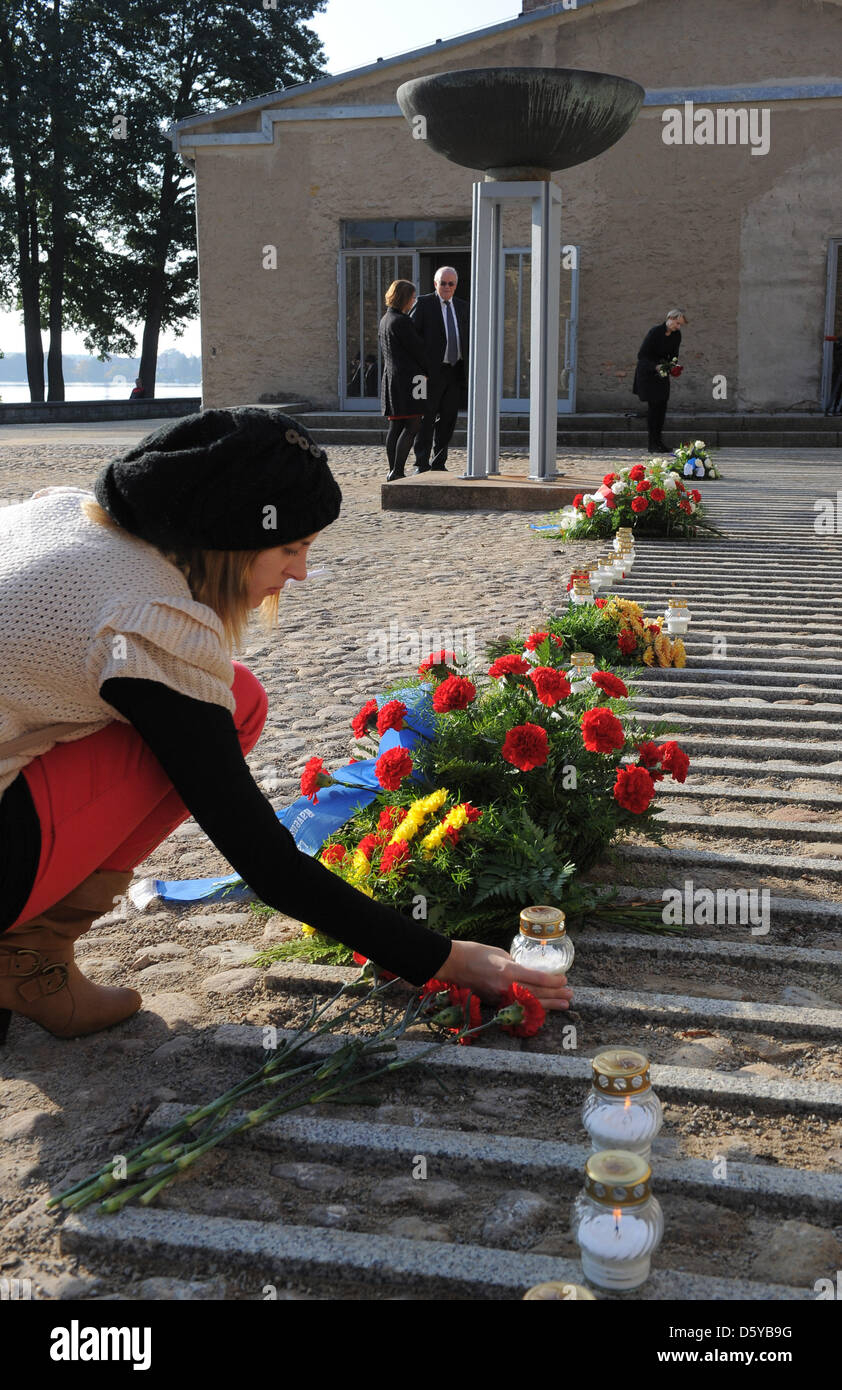 A girl puts a candle at a newly discovered gravesite at former concentration camp Ravensbrueck in Fuerstenberg, Germany, 21 October 2012. A previously unknown grave of ashes of victims of National Socialism was found during construction works in the courtyard of the crematorium. Photo: Bernd Settnik Stock Photo