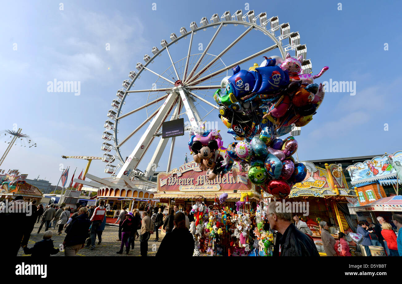 Visitors walk past the Ferris wheel at Freimarkt funfair in Bremen, Germany, 21 October 2012. The Northern German folk festival takes place for the 977th time and constinues til 04 November 2012. Photo: Carmen Jaspersen Stock Photo