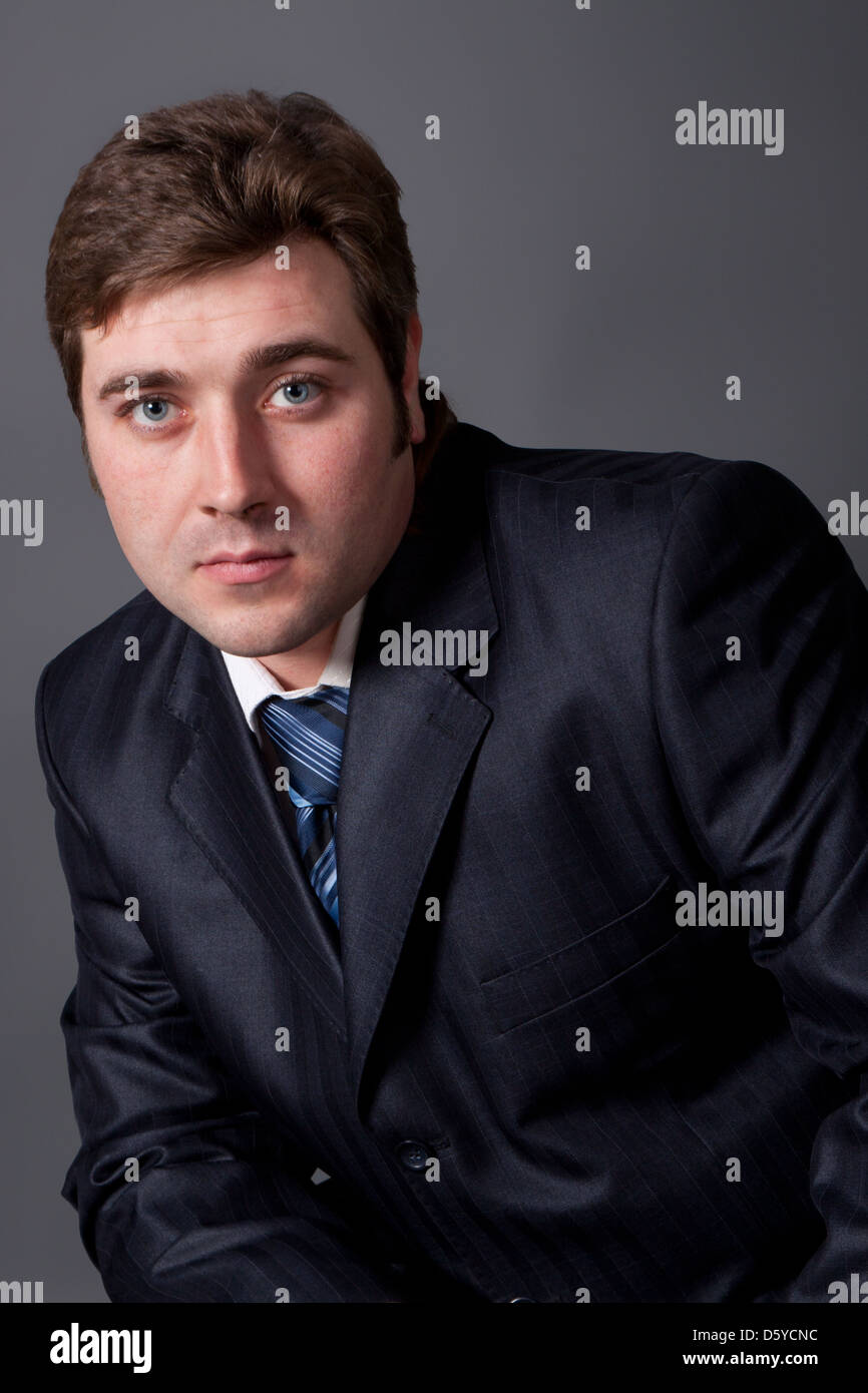 portrait of a young man in a black suit with a gray background Stock ...