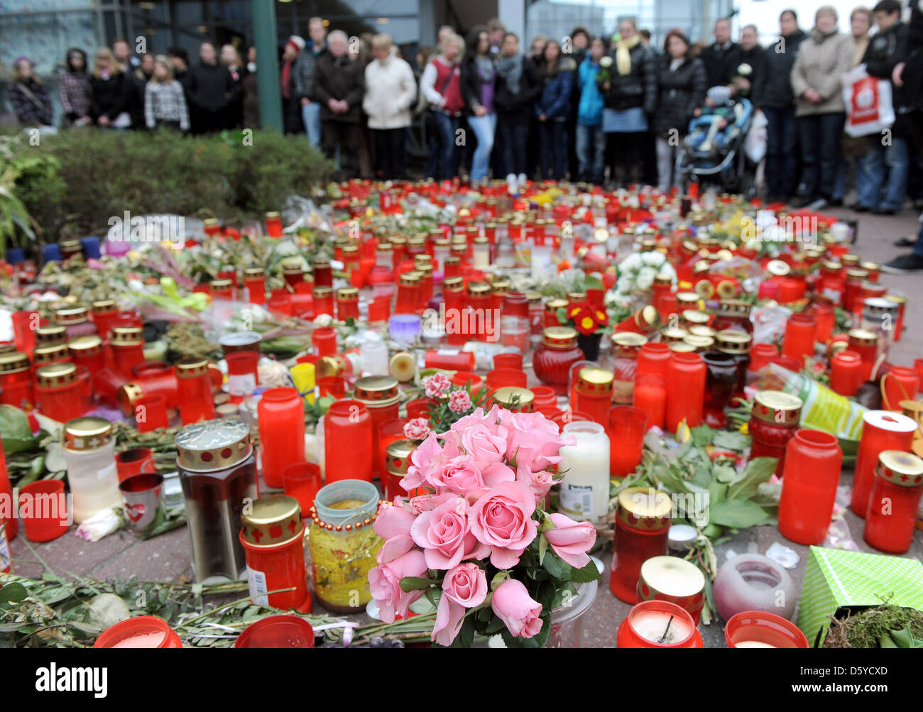 Around 200 users of the social network Facebook remember murdered 11 year old Lena with flowers and candles at City-Parkhau in Emden, Germany, 04 April 2012. Previously, there was a rally to apologize to the innocent 17 year old who was arrested in connection with the murder of Lena. An 18 year old arrested on 31 March has admitted to the crime. Photo: INGO WAGNER Stock Photo