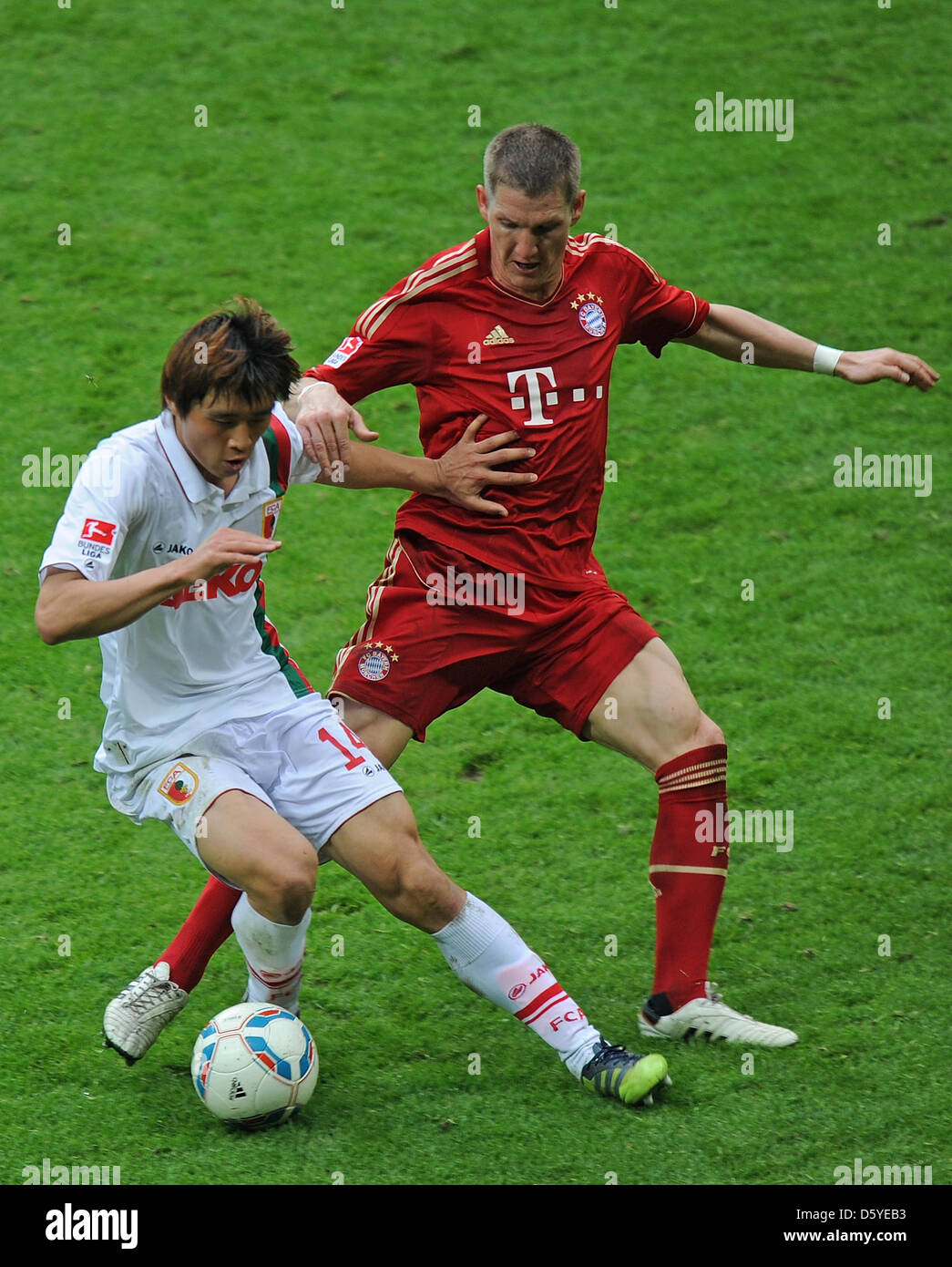 Munich's Bastian Schweinsteiger (R) vies for the ball with Augsburg's Ja-Cheol Koo during the German Bundesliga match between FC Bayern Munich and FC Augsburg at Allianz Arena in Munich, Germany, 07 April 2012. Munich won the match 2-1. Photo: MARC MUELLER (ATTENTION: EMBARGO CONDITIONS! The DFL permits the further utilisation of the pictures in IPTV, mobile services and other new  Stock Photo
