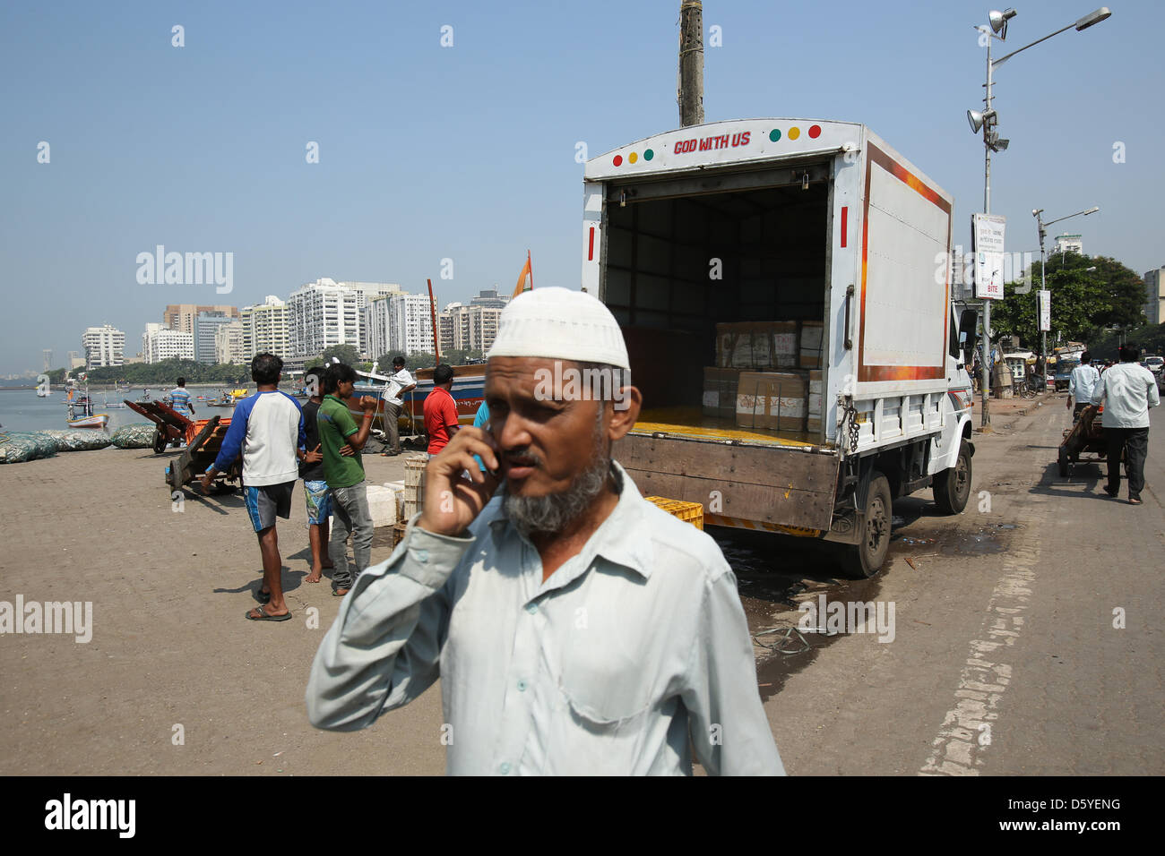 Men load boxes with fresh fish onto a transporter at a small fishing ...