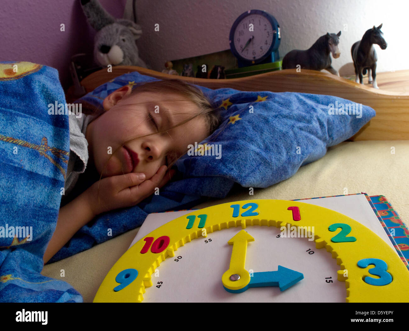 ILLUSTRATION - Amy (6) sleeps next to her children's clock in Sieversdorf, Germany, 19 october 2012. In the night from 27 to 28 October, the clocks are adjusted backward marking the start of winter time in Europe. Photo: Patrick Pleul Stock Photo