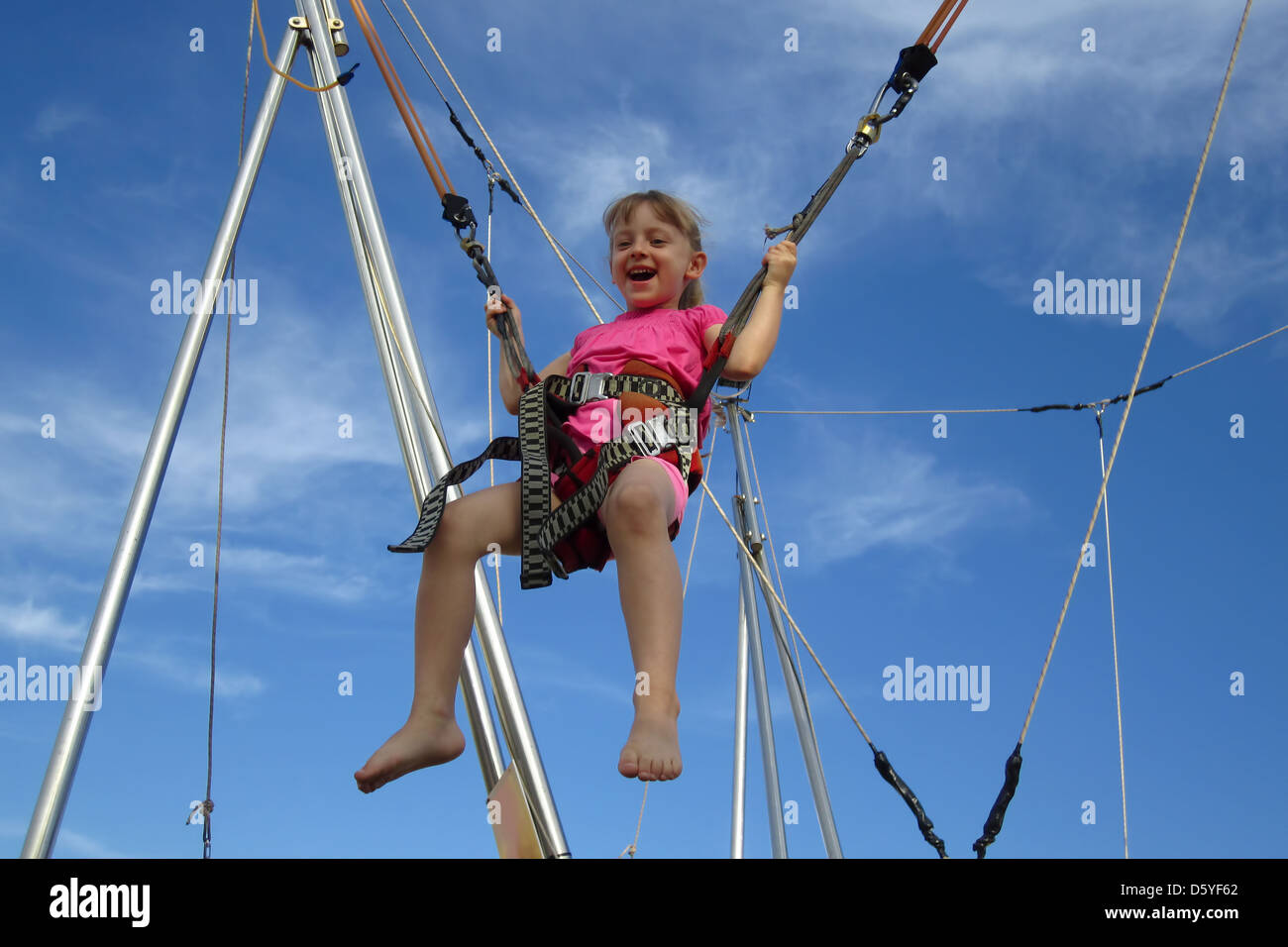 Girl bungee jumping on a trampoline Stock Photo Alamy