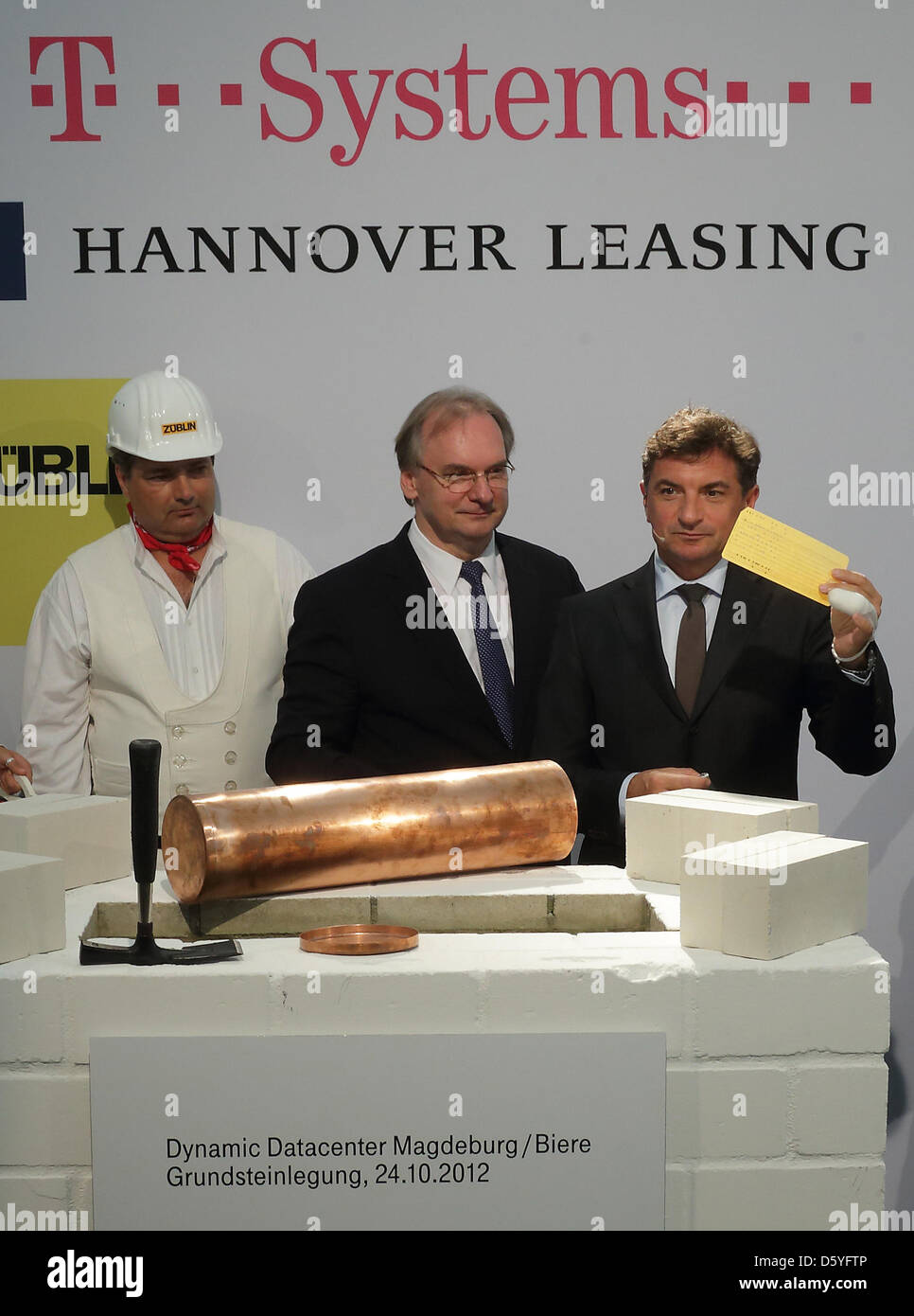Foreman Ingo Pfitzner (L-R), Premier of Saxony-Anhalt Reiner Haseloff and Ferri Abolhassan, T-Systems CEO of Production, lay the foundation stone for the data processing center of Deutsche Telekom which will be build in Biere, Germany, 24 October 2012. Telekom subsidiary T-Systems will operate the computer center from 2014, which allows the company to meet the growing demand for cl Stock Photo