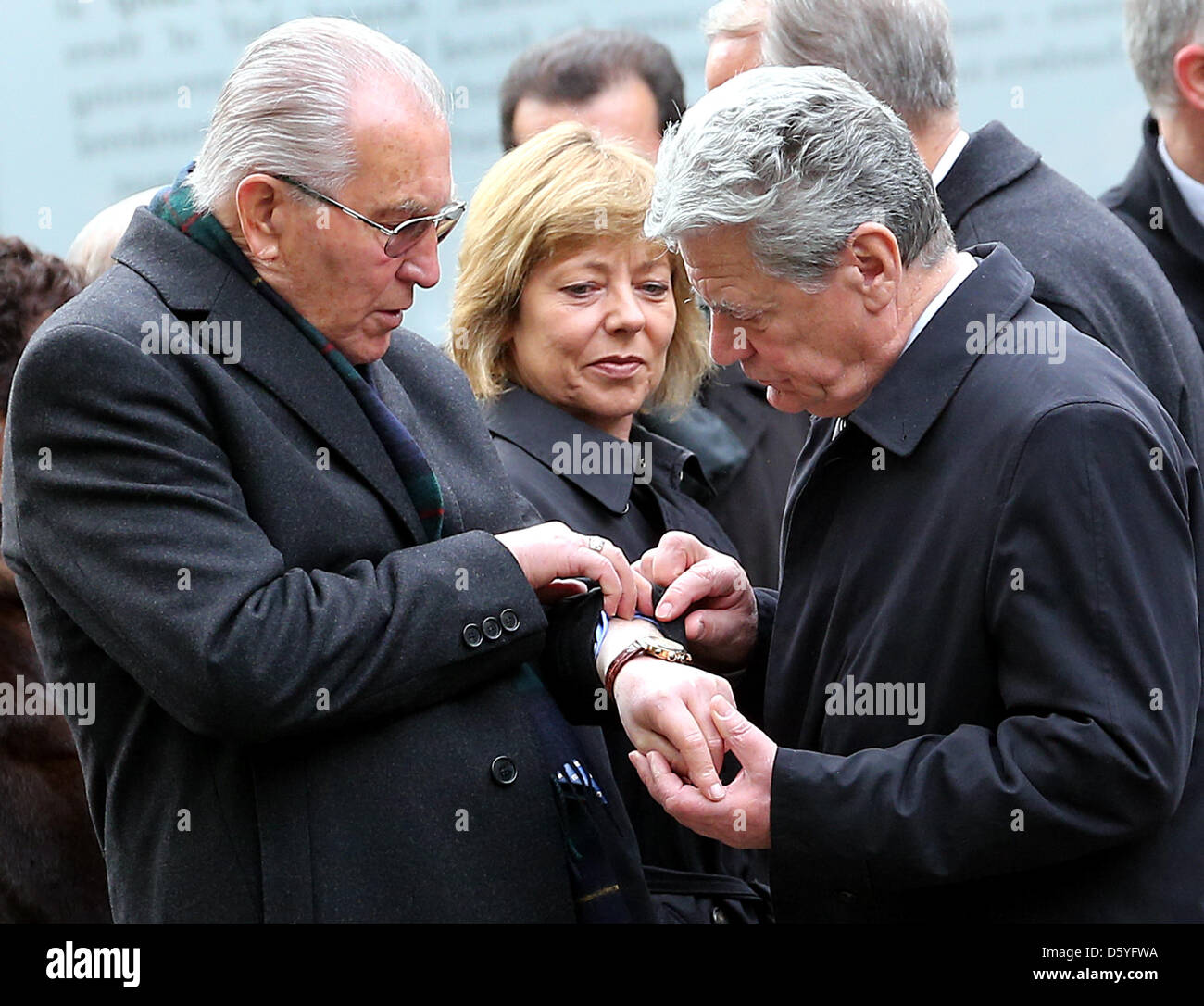 Survivor of the Holocaust Zoni Weisz (L) shows his concentration camp tattoo to German President Joachim Gauck and his partner Daniela Schadt during the inauguration of the memorial to the Sinti and Roma murdered under National Socialism in Berlin, Germany, 24 October 2012. German chancellor Angela Merkel is mirrored in the center. Around 70 years after the end of World War II the  Stock Photo