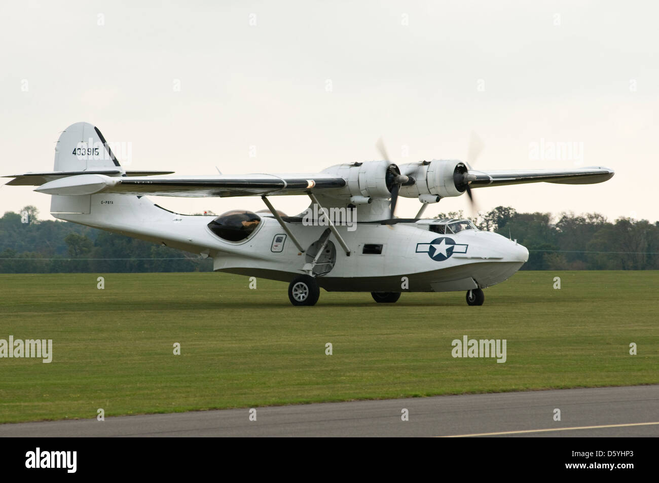 A vintage USAF Catalina 'sea plane' on an airfield, engines running shortly after landing. Stock Photo