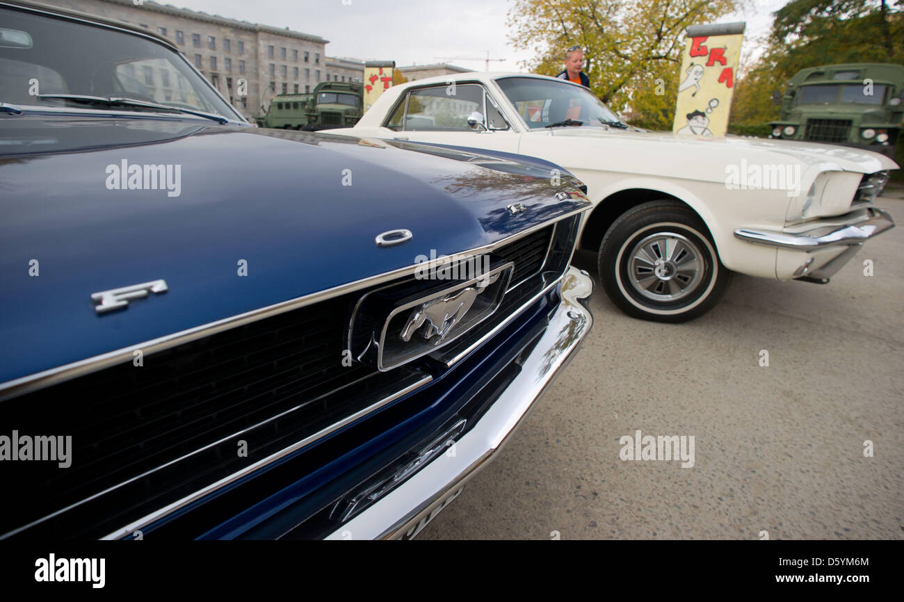 A blue and a white Ford Mustang from the 60s are pictured during a