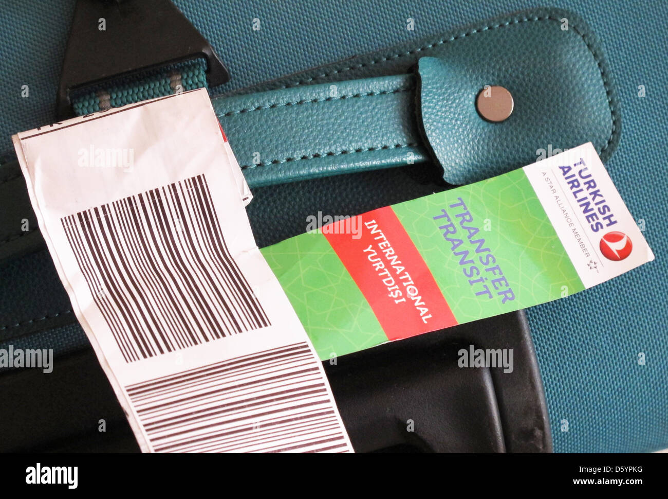 A luggage lable with bar code and a badge for transit transfer is attached  to a suitcase after an international flight in Berlin, Germany, 07 October  2012. Photo: Jens Kalaene Stock Photo - Alamy