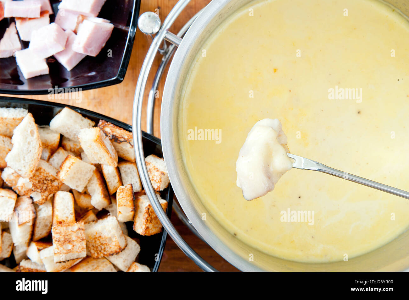 Fork over cheese fondue pot Stock Photo Alamy