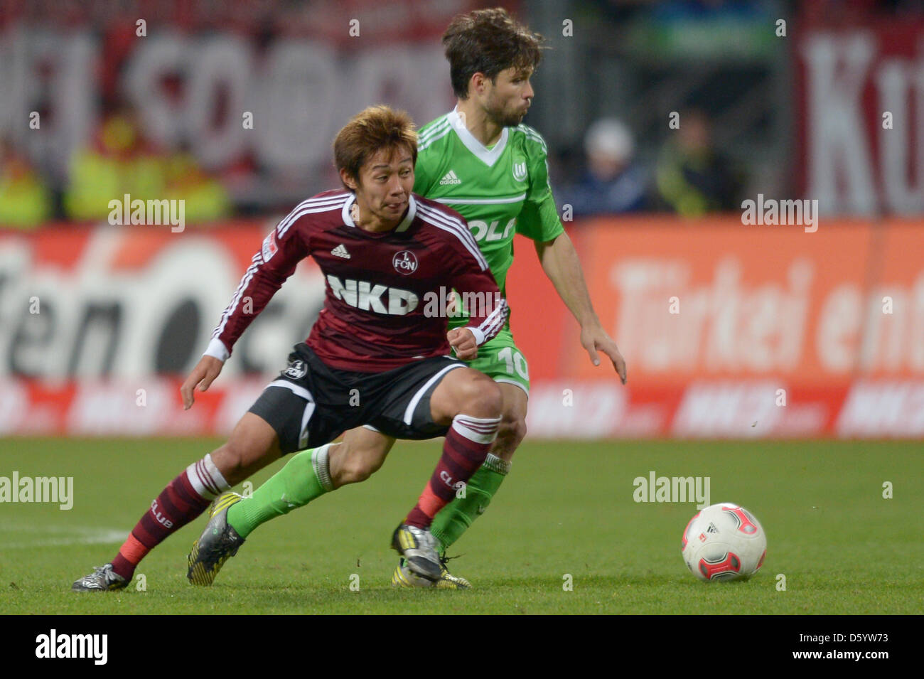 Wolfsburg's Diego (r) tackles Nuremberg's  Hiroshi Kiyotake (l) during a German Bundesliga match between 1 FC Nuremberg and VfL Wolfsburg at easyCredit stadium in Nuermberg, Germany, 3 November 2012. Photo: DAVID EBENER    (ATTENTION: EMBARGO CONDITIONS! The DFL permits the further utilisation of up to 15 pictures only (no sequntial pictures or video-similar series of pictures allo Stock Photo