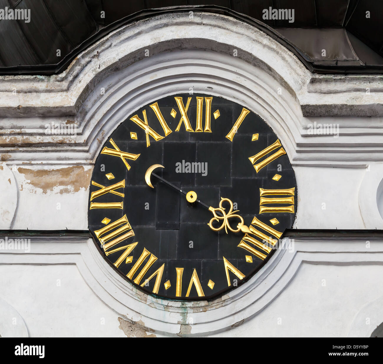 Vintage tower clock with roman numerals on white church wall in old part of Tallinn, Estonia Stock Photo