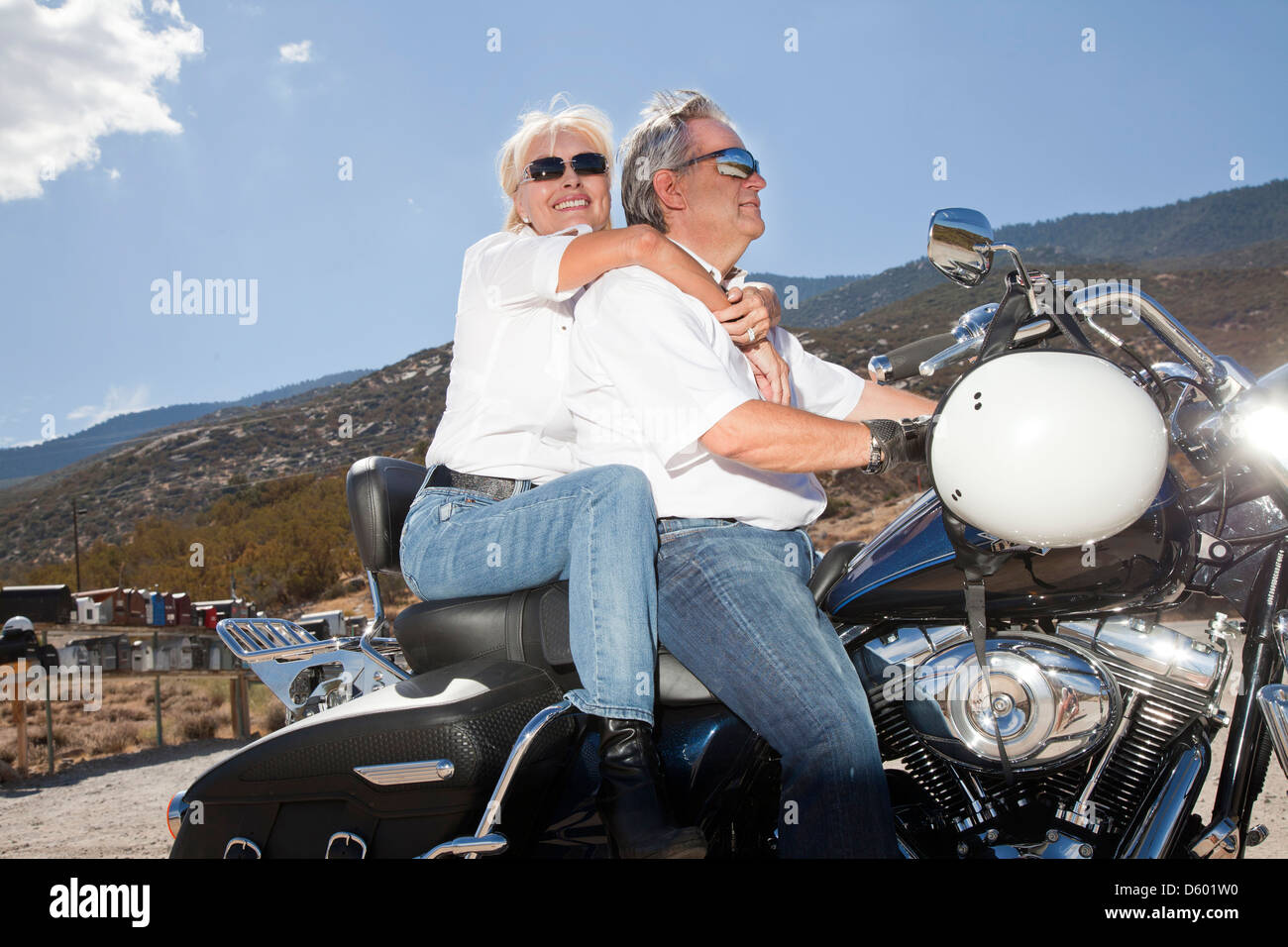 Senior couple riding  motorcycle together in  rural landscape Stock Photo