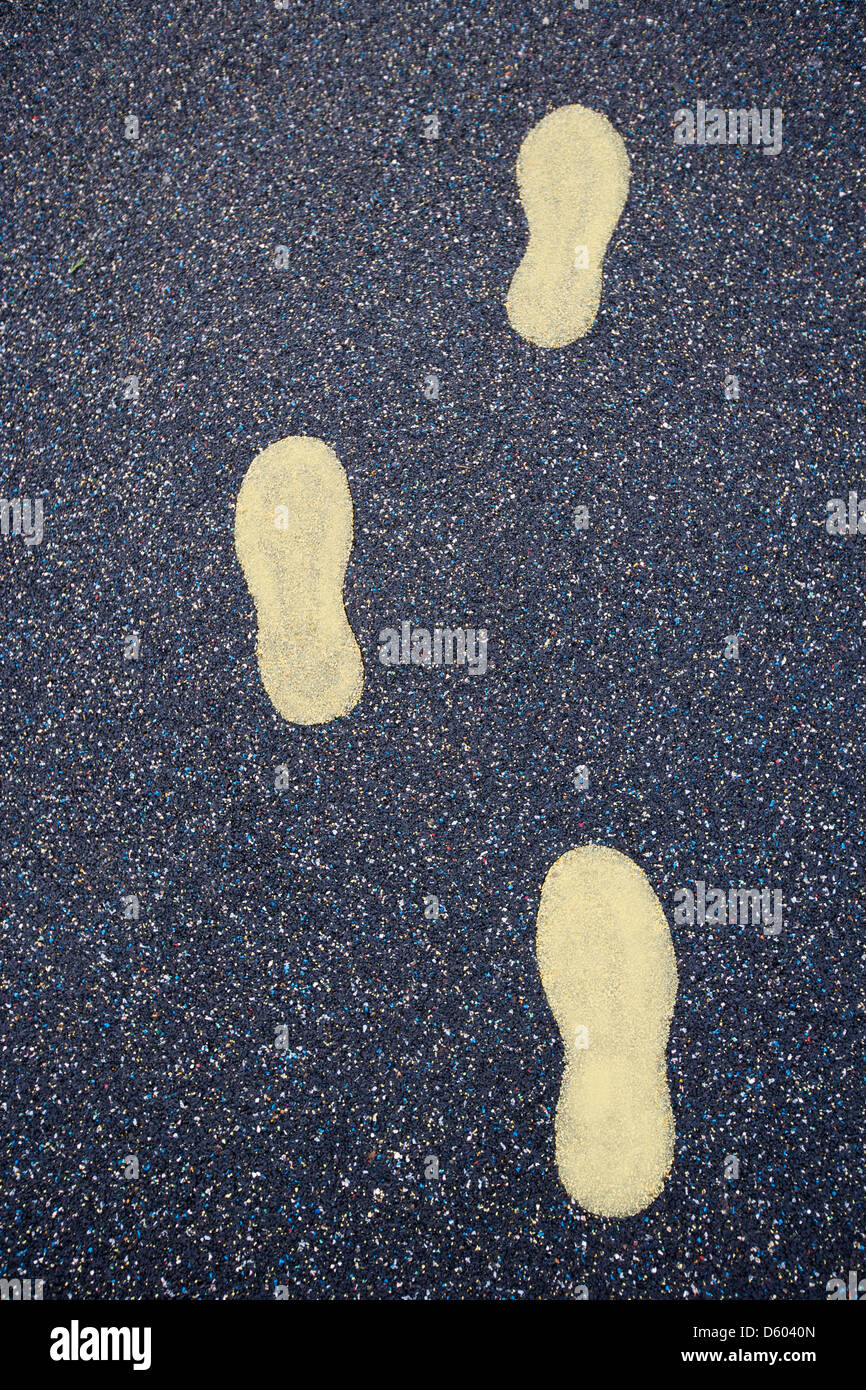 Yellow footsteps drawn in playground rubber flooring Stock Photo