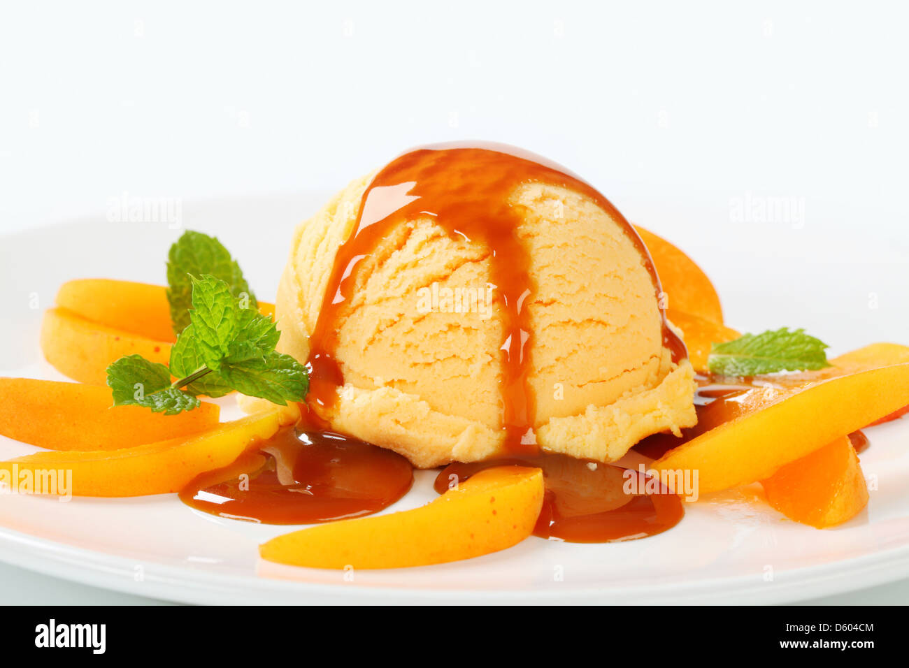 Ice cream with fresh apricot slices and caramel sauce Stock Photo Alamy
