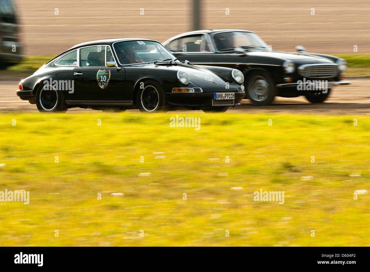 A Porsche 911 E (l) and a Volvo P 1800 are pictured during the Oldtimer Rallye 'Revival Berlin' at Trabrennbahn Mariendorf in Berlin, Germany, 10 November 2012. More than 50 historical automobiles compete for highest speed, some of them are piloted by former motor sportsmen. Photo: Robert Schlesinger Stock Photo